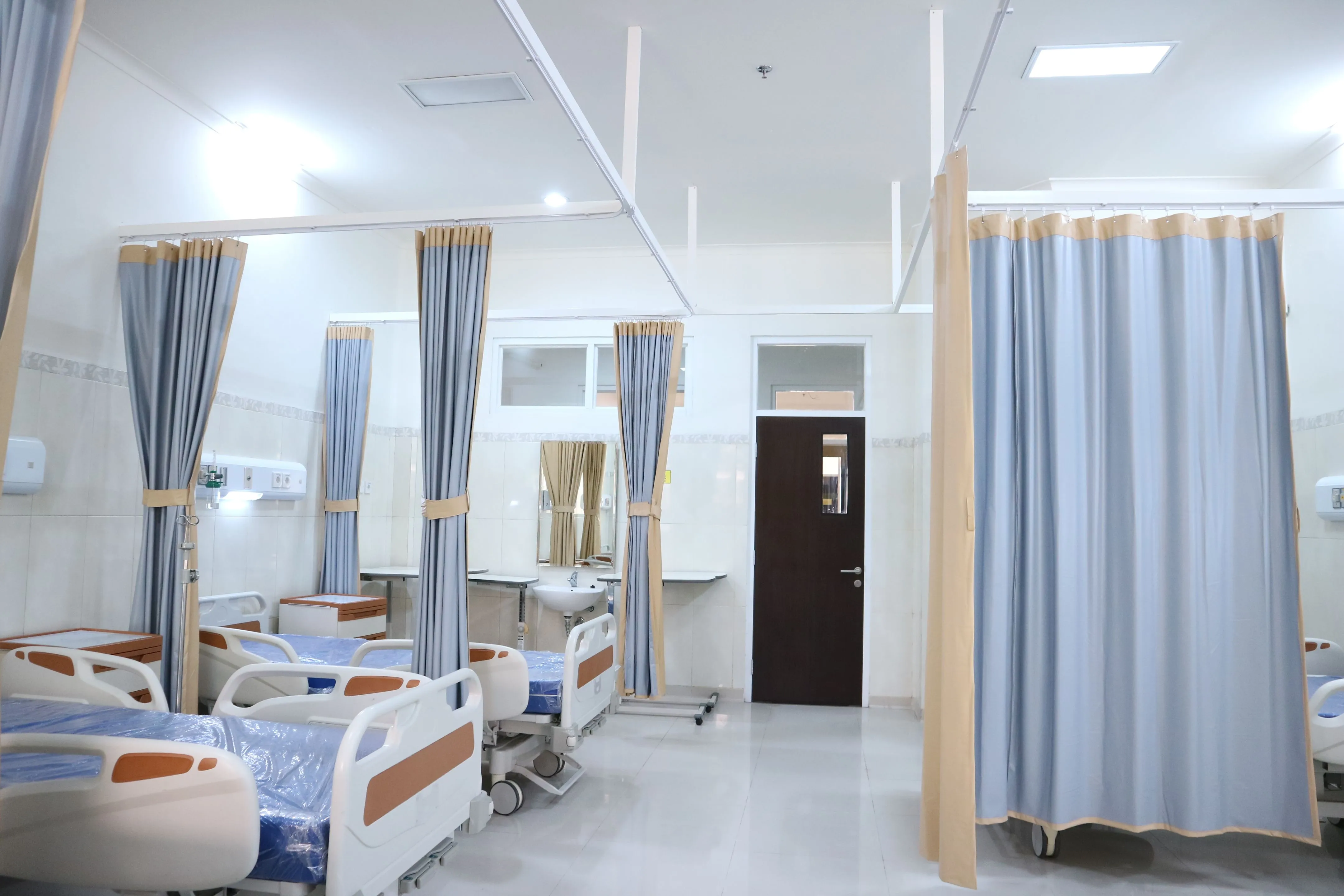 Beds and privacy curtains in a quiet hospital ward